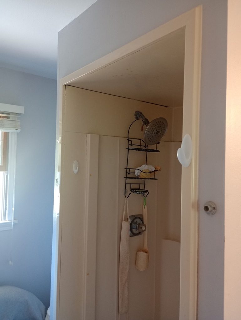 Dated fiberglass shower stall before the bathroom remodel