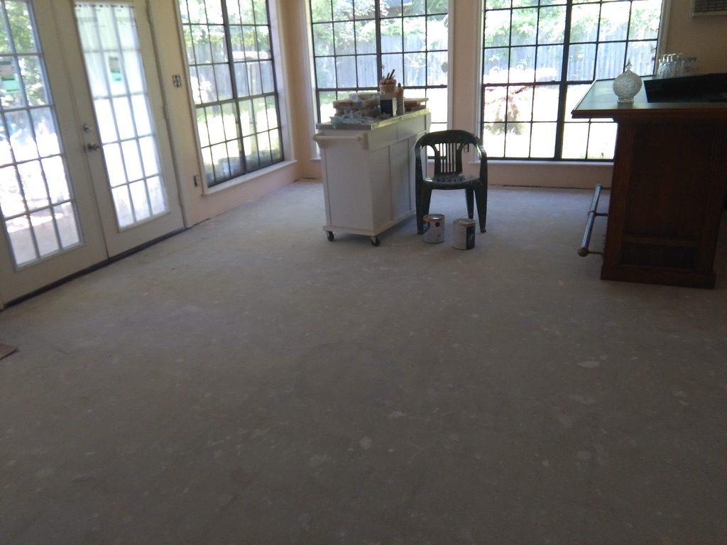 Sunroom with bare concrete floor before refinishing